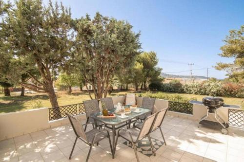 un patio con tavolo, sedie e griglia di Villa Zavria ad Argásion