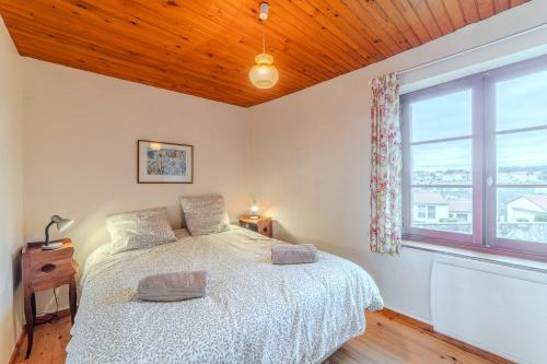 a bedroom with a bed and a large window at La grange du Petit Roure - A 20 km de Saint-Etienne in Grand Roure