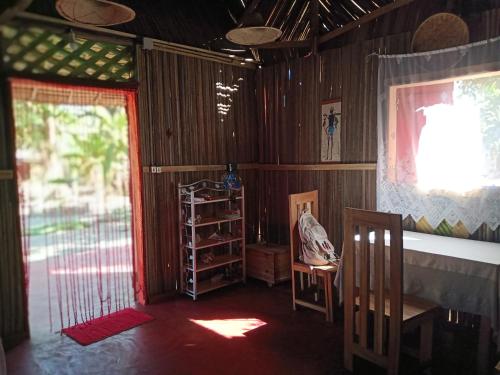 a room with a table and chairs and a window at Maison Des Voyageurs in Ambanja