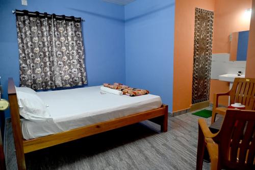 een slaapkamer met een bed en een blauwe muur bij Happy Homestay in Māvalli