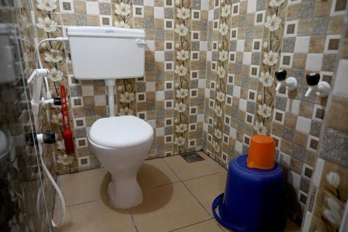 een badkamer met een toilet en een blauwe emmer erin bij Happy Homestay in Māvalli