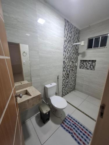 ein Badezimmer mit Toilette, Waschbecken und Dusche in der Unterkunft Chalé das Palmeiras in Itabaiana