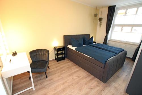a bedroom with a bed and a desk and a chair at Gästewohnung "ZeitRaum" in Halberstadt