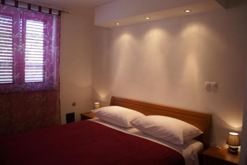sypialnia z łóżkiem z 2 poduszkami i oknem w obiekcie Apartment Adria Sun w mieście Porat