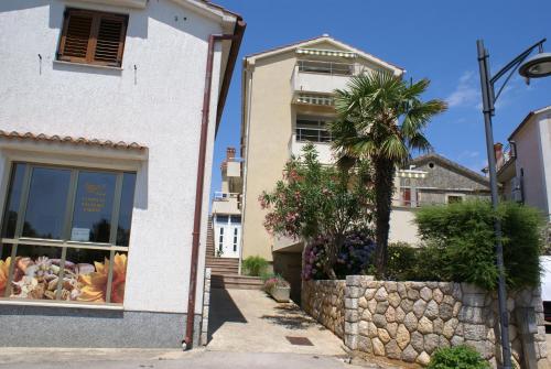 a building with a palm tree in front of it at Apartment Adria Sun in Porat