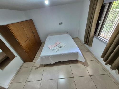 a room with a bed with a towel on it at Residencial Jardim Curitiba in Curitiba