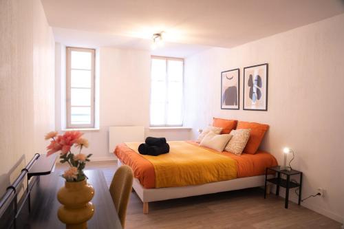 Hyères centre, 2 chambres, idéal pour famille في هييريس: غرفة نوم مع سرير وبطانية برتقالية