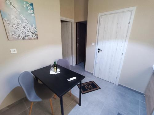 a black table and chairs in a room with a door at knezevic resorts 14 in Mesochórion