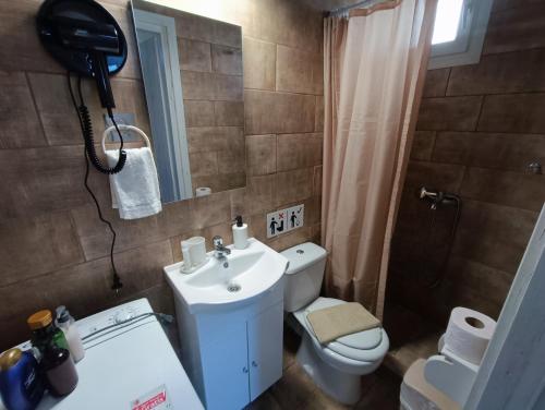 a bathroom with a sink and a toilet and a mirror at knezevic resorts 14 in Mesochórion