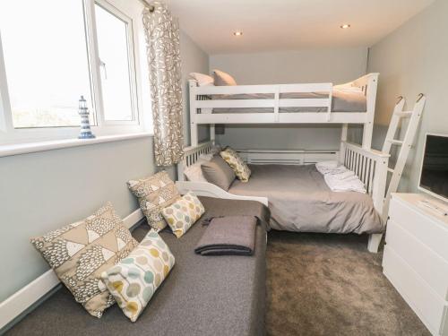 a small room with two bunk beds and a couch at Dunholme in Holyhead