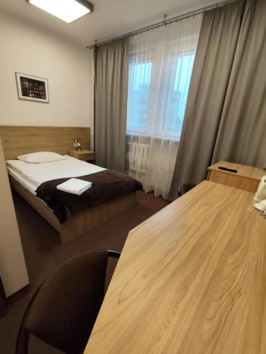 a hotel room with a bed and a table at Dom Studenta nr 1 in Siedlce