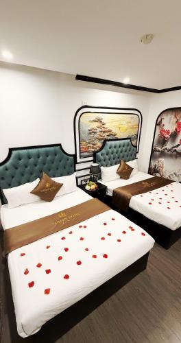 two beds in a hotel room with hearts on them at Golden Hotel in Hanoi
