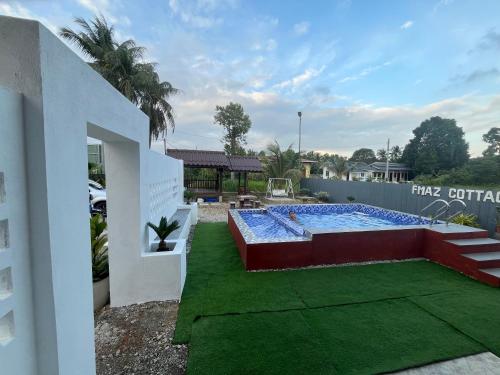 a swimming pool in the backyard of a house at FMAZ Cottage in Kampong Gong