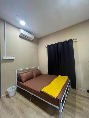 a bed in a room with a black curtain at FMAZ Cottage in Kampong Gong
