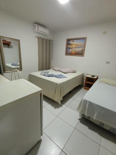 a hotel room with two beds and a mirror at Hotel Internacional in Cianorte