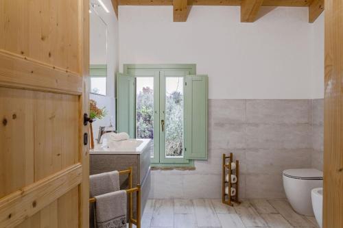 een badkamer met een wastafel en een toilet en een raam bij Italian Experience-Villa Zena in San Paolo di Iesi