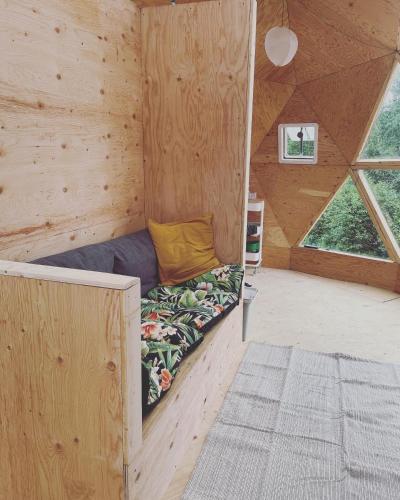 a room with a bed in a wooden cabin at Prêt-à-camper, dôme in La Tuque
