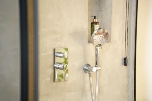 a shower with a soap dispenser on a wall at Moonlight Apartments Tirana in Tirana