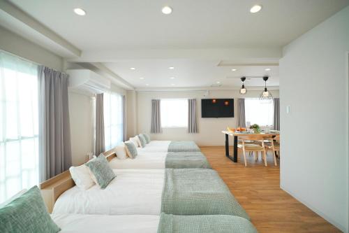 a row of beds in a room with a table at Unite Stay Urayasu201 Close to Disneyland, 15 minutes by bus, 8 minutes by car, and good access from the nearest station to Tokyo Station, Ginza, and Asakusa in Tokyo