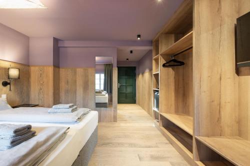 a bedroom with wooden walls and a bed with towels at Ranunkelhof in Pirna