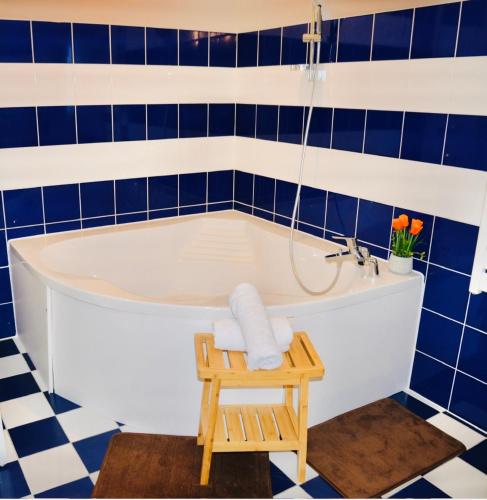 a bath tub in a bathroom with blue tiles at Maison bonheur -Parking- piscine -espace de jeux- avec 6 suites avec SDB in Bourg-en-Bresse