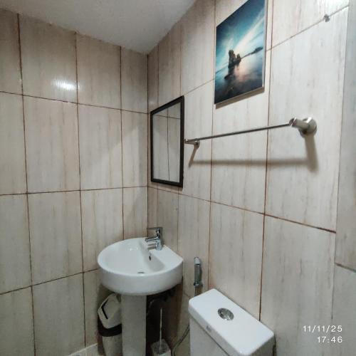 a bathroom with a sink and a mirror and a toilet at 8Adriatico Condo near US Embassy in Manila
