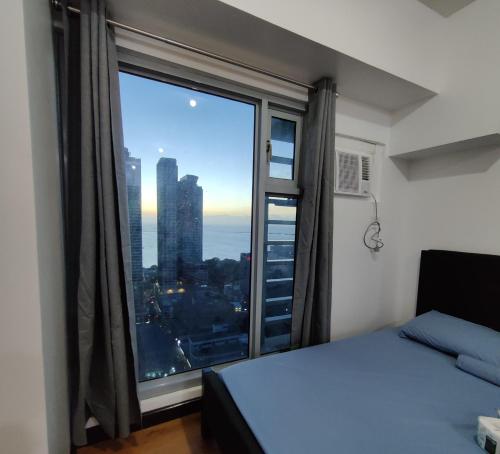 a bedroom with a large window with a view of the city at 8Adriatico Condo near US Embassy in Manila