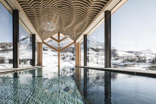 una piscina en un edificio con ventanas en Miraval NaturHotel, en Badia