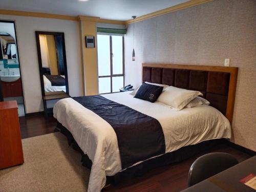 パストにあるHotel Casa Madrigalの大きなベッドとバスルームのある寝室