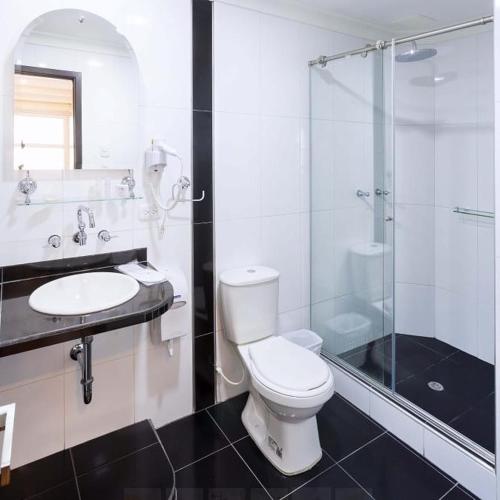 a bathroom with a toilet and a glass shower at Hotel Casa Madrigal in Pasto