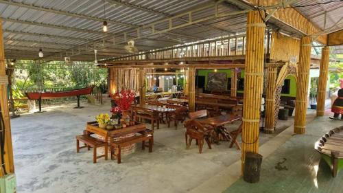 a pavilion with wooden tables and benches in a room at Baan Gamnan Resort Krabi in Ban Khao Ngam