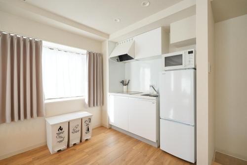 a kitchen with a white refrigerator and a window at Unite Stay Urayasu201 Close to Disneyland, 15 minutes by bus, 8 minutes by car, and good access from the nearest station to Tokyo Station, Ginza, and Asakusa in Tokyo