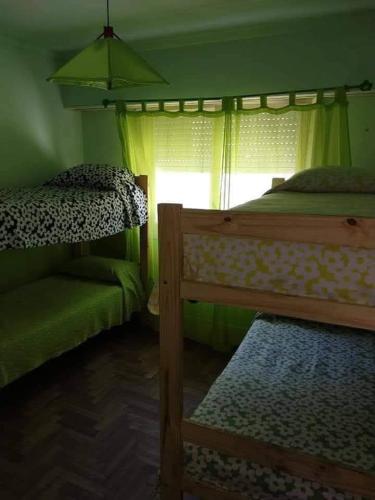 Mar del Plata house في مار ديل بلاتا: غرفة نوم بها سريرين بطابقين ونافذة