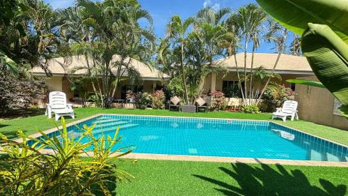 a swimming pool in front of a house at Villa Sun 4 in Mae Nam
