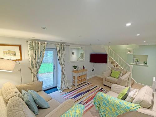 un soggiorno con 2 divani e una scala di Riverview Cottage a Hartington