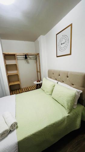 1 dormitorio con 1 cama grande con sábanas verdes en Mar Perto, Estilo e Conforto, en Ilha da Restinga