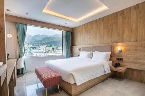 a bedroom with a large bed and a large window at Hotel Meriken in Dharān Bāzār