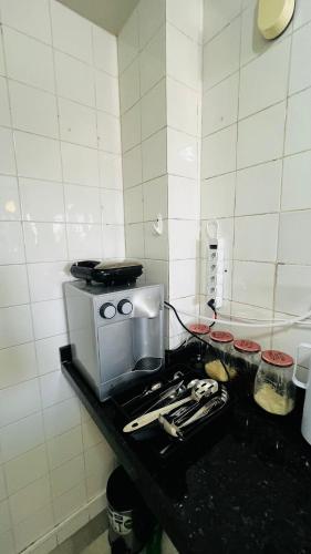 encimera de cocina con fogones y microondas en Mar Perto, Estilo e Conforto, en Ilha da Restinga