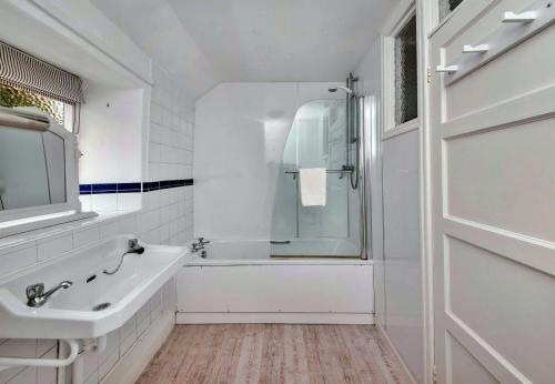 een witte badkamer met een bad en een wastafel bij Finest Retreats - Catterick Cottage in Catterick Bridge