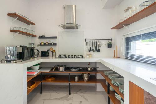 a kitchen with white counters and a counter top at Gandum Villa Complex - Luxury Boutique Stay Uluwatu in Uluwatu