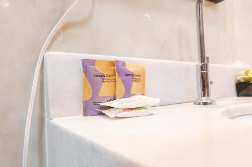 马拉戈日Pousada Antonella的白色台面上放着两包牙膏