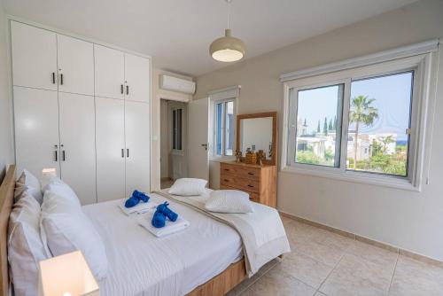 Seaview Villa Selenia pool & jacuzzi in Neo Chorio في نيو تشوريو: غرفة نوم بها سرير أبيض كبير مع نافذة