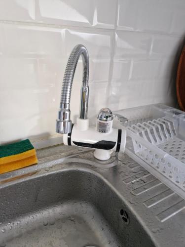 a kitchen sink with a faucet and a dish rack at Apartment close to the sea in the most central of city in Antalya