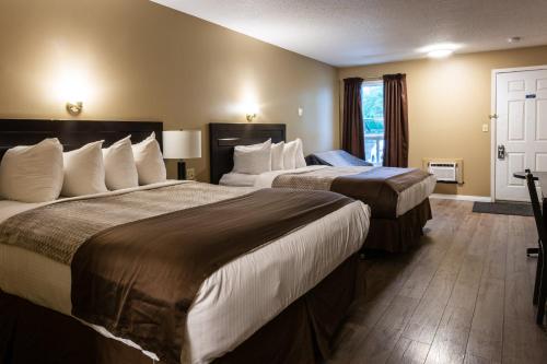 een hotelkamer met twee bedden en een raam bij Chinook Country Inn in Sundre
