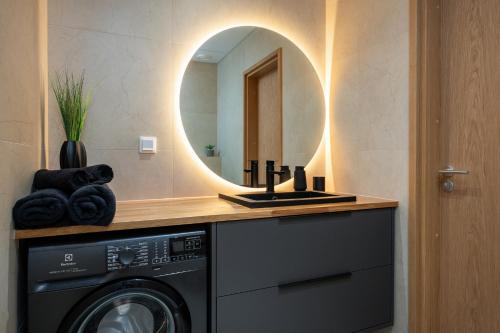 a bathroom with a washing machine and a mirror at Cosy River Suite in Tartu