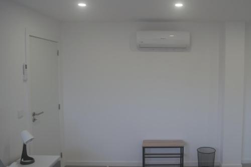 a white wall with a lamp and a table at Casas da Travessoa in Marco de Canaveses