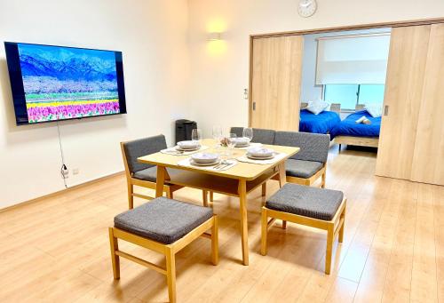 a living room with a table and chairs and a tv at MY HOUSE たいみんぐ kuwana 長島15分 名古屋20分 桑名駅徒歩3分 in Kuwana