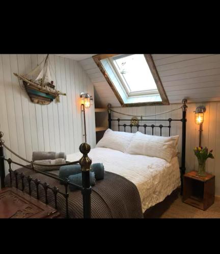 een slaapkamer met een groot bed en een raam bij Fisherman's Cottage in Orkney