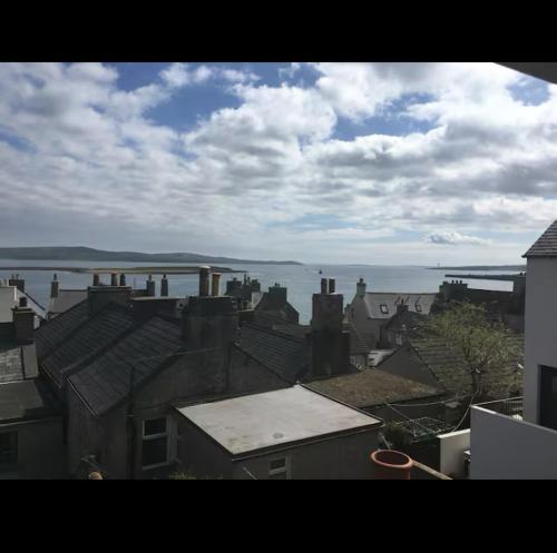 uitzicht op daken van huizen en het water bij Fisherman's Cottage in Orkney