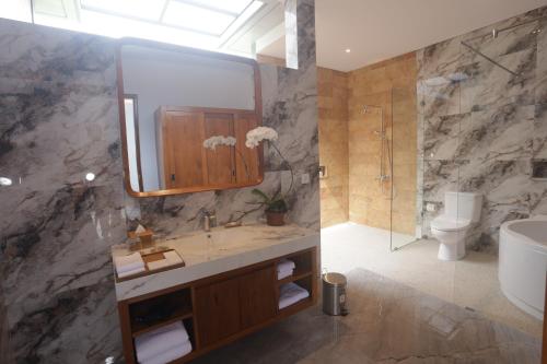 ein Badezimmer mit Waschbecken und Spiegel in der Unterkunft Villa Diva in Ketewel